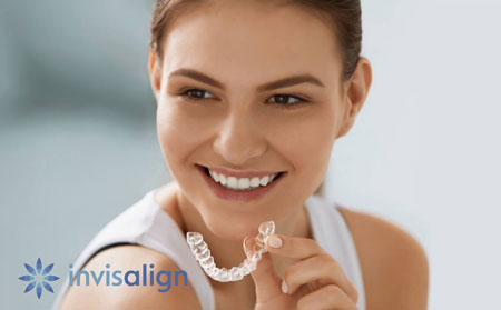 patient holding her new Invisalign clear aligners she received from Bonham Dental Arts