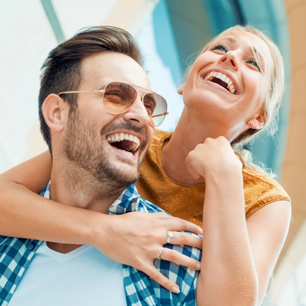 Cosmetic Dentistry 1 Couple laughing together outdoors with bright healthy smiles from Bonham Dental Arts in Largo